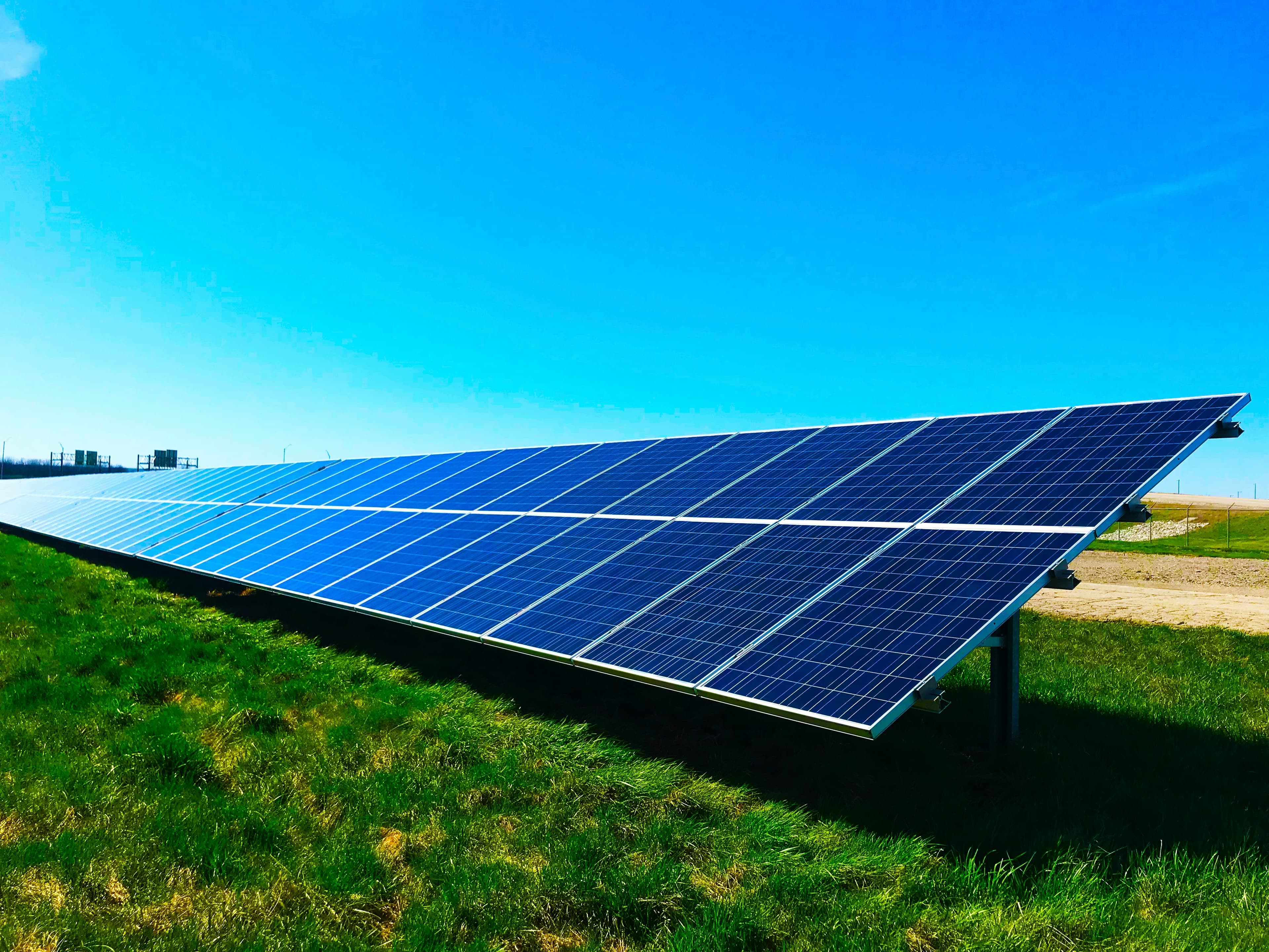 Vast rooftop solar panel installation reflecting the morning sun.